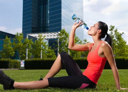 Woman drinking water after exercising
